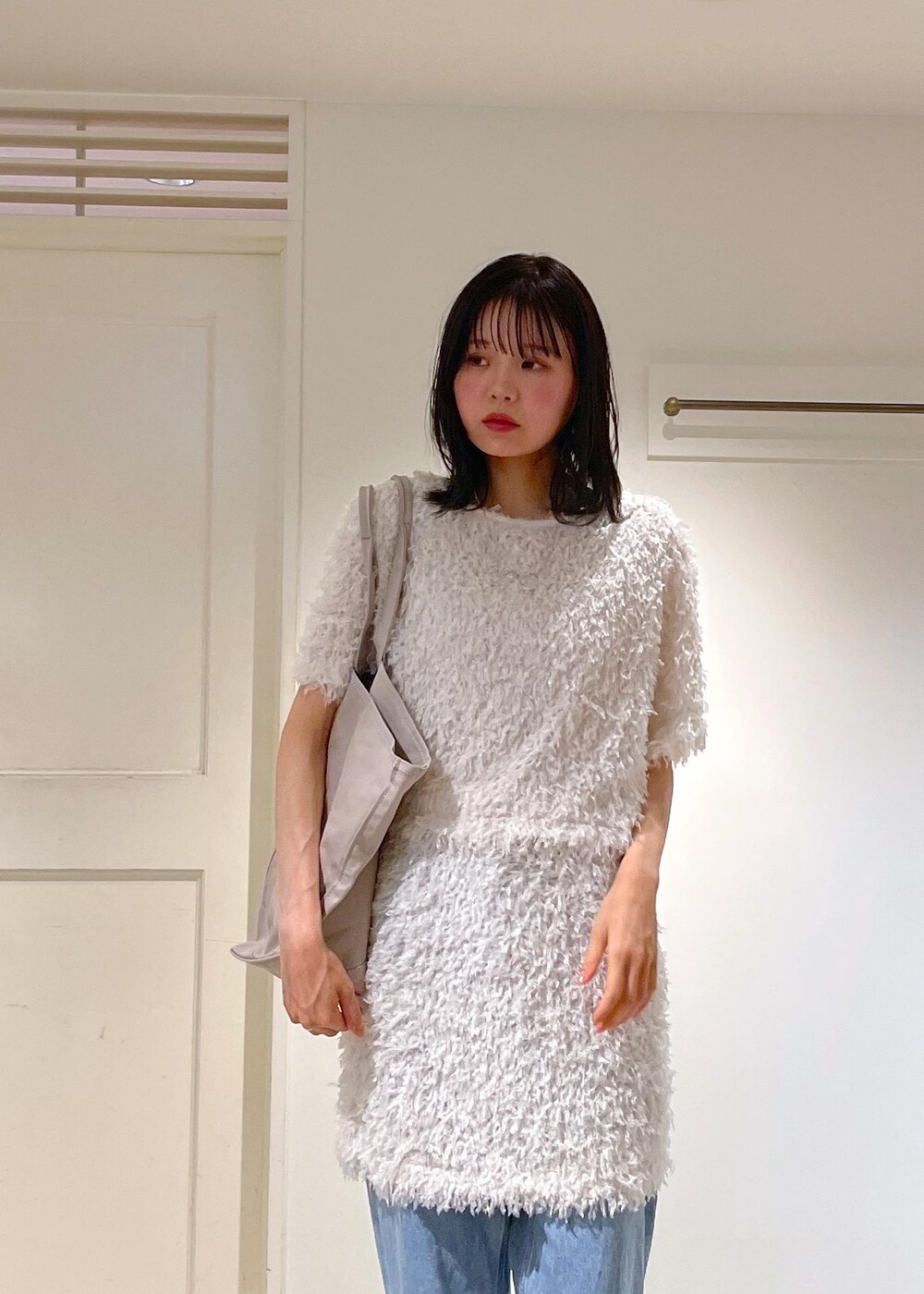 ブルー系のデニムパンツ、ホワイト系のスカート、ホワイト系のTシャツ/カットソーを着用したレディースの夏コーディネートの5枚目の写真