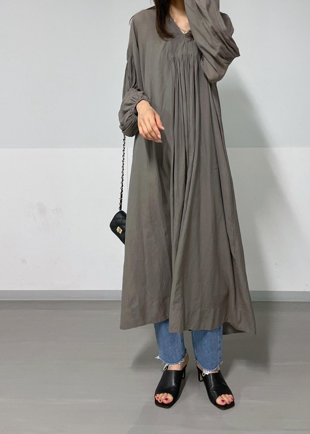 ブラック系のショルダーバッグ、グリーン系のタンクトップ、グレー系のワンピースを着用したレディースの夏コーディネートの6枚目の写真