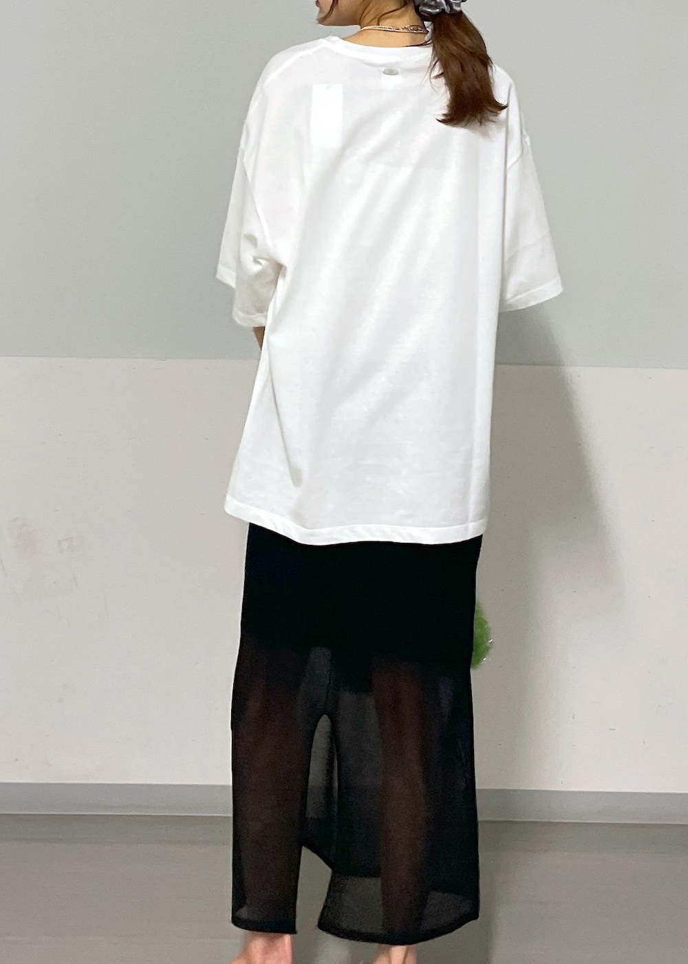 ブラック系のスカート、グリーン系のハンドバッグ、ホワイト系のTシャツ/カットソーを着用したレディースの夏コーディネートの8枚目の写真