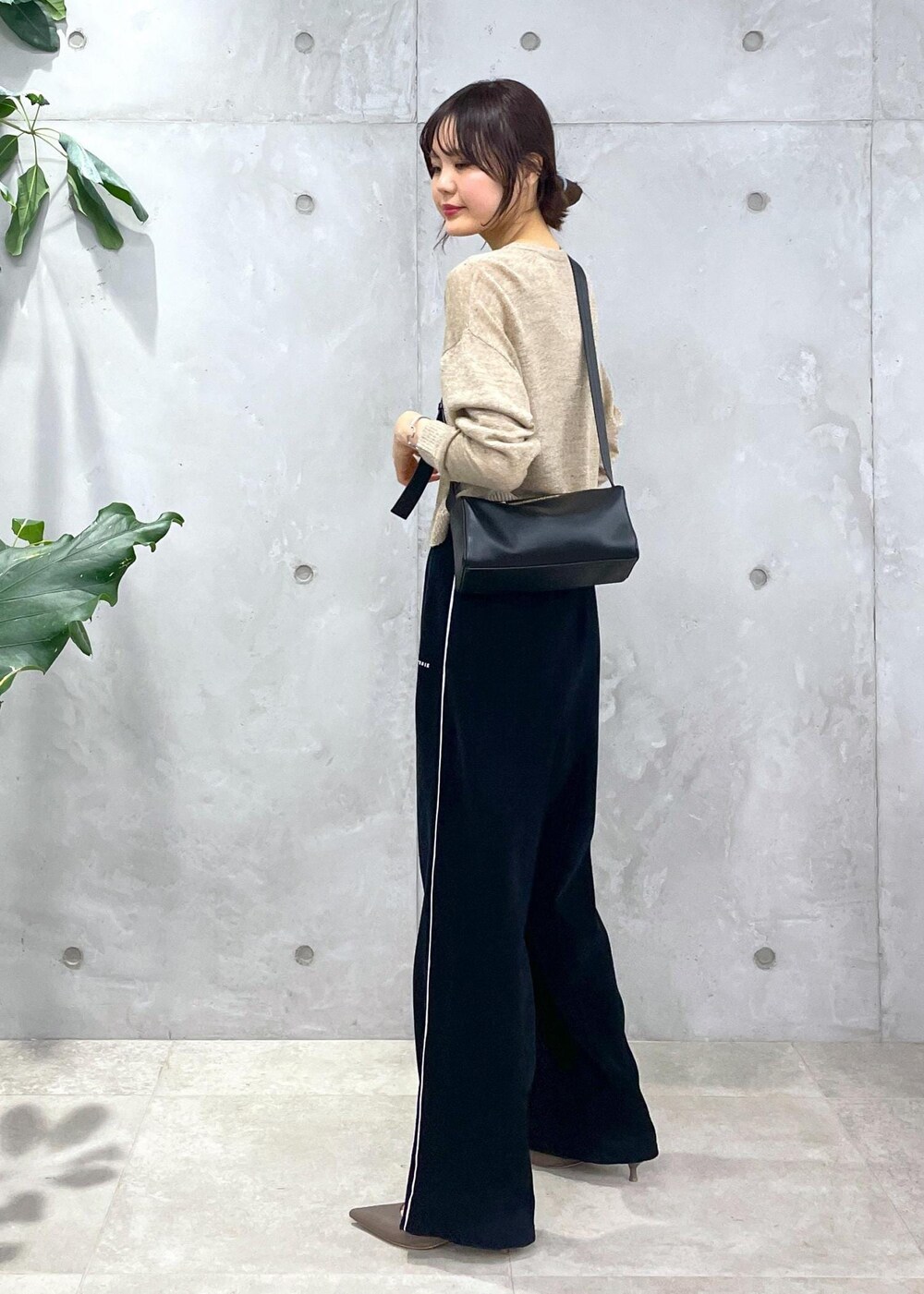ブラック系のショルダーバッグ、ブラック系のその他パンツ、ベージュ系のカーディガン/ボレロを着用したレディースの冬コーディネートの5枚目の写真