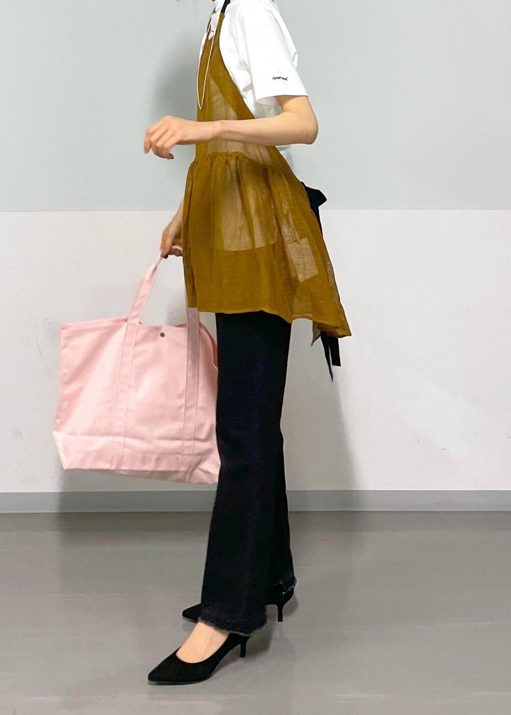 グレー系のデニムパンツ、ホワイト系のTシャツ/カットソー、ブラウン系のベストを着用したレディースの春コーディネートの9枚目の写真