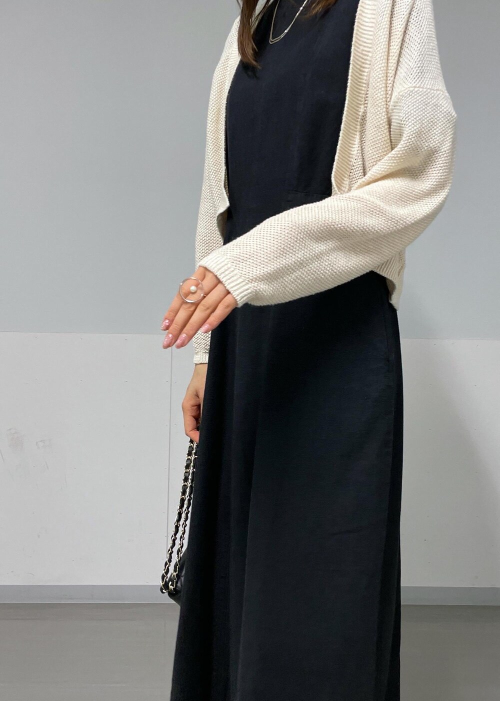 ブラック系のサンダル、ホワイト系のカーディガン/ボレロ、ブラック系のワンピースを着用したレディースの夏コーディネートの8枚目の写真