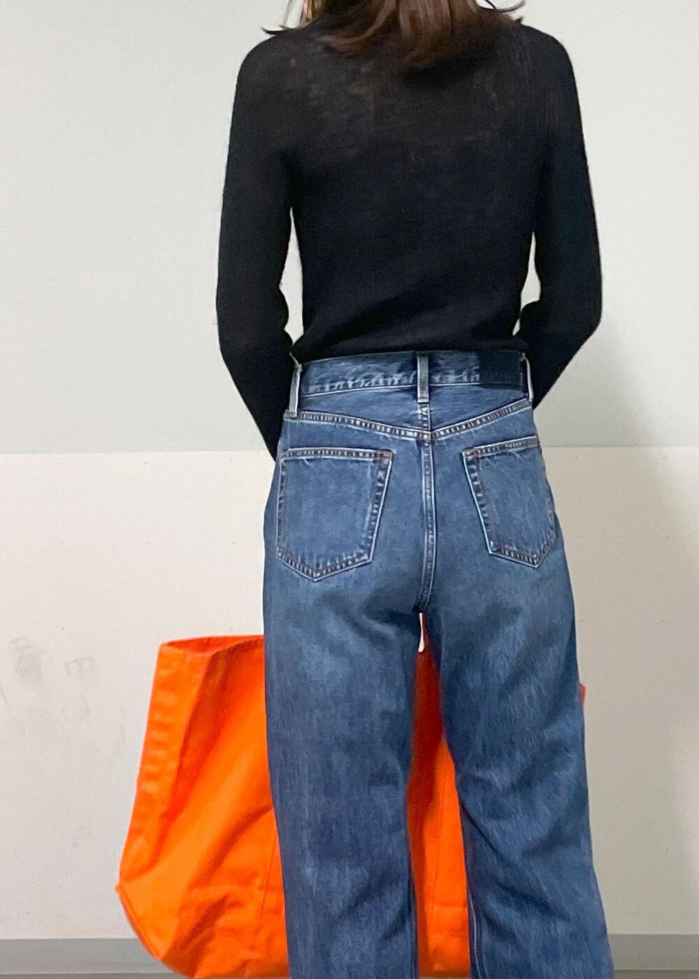 グレー系のタンクトップ、ブラック系のカーディガン/ボレロ、ブルー系のデニムパンツを着用したレディースの秋コーディネートの7枚目の写真