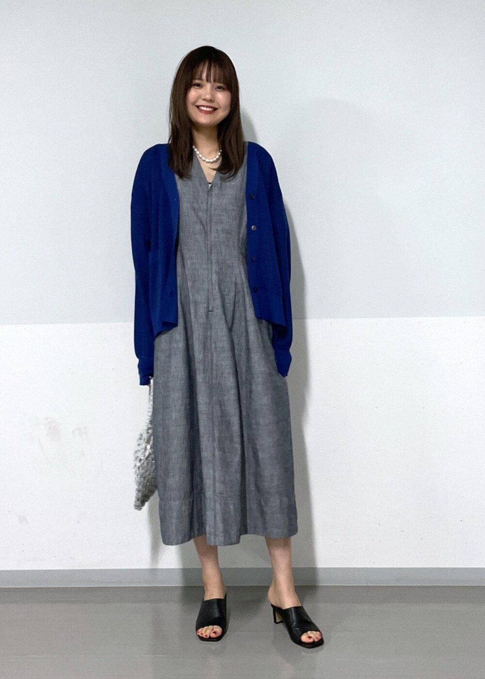 ブラック系のサンダル、ホワイト系のハンドバッグ、ブルー系のカーディガン/ボレロを着用したレディースの夏コーディネートの9枚目の写真