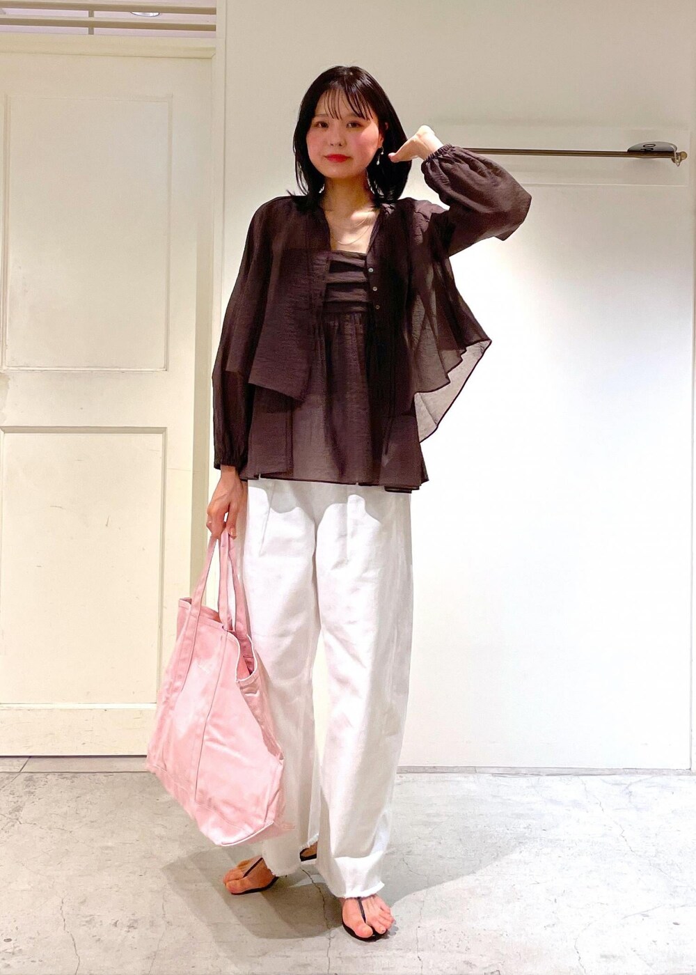 グレー系のタンクトップ、ブラック系のサンダル、ホワイト系のデニムパンツを着用したレディースの夏コーディネートの4枚目の写真