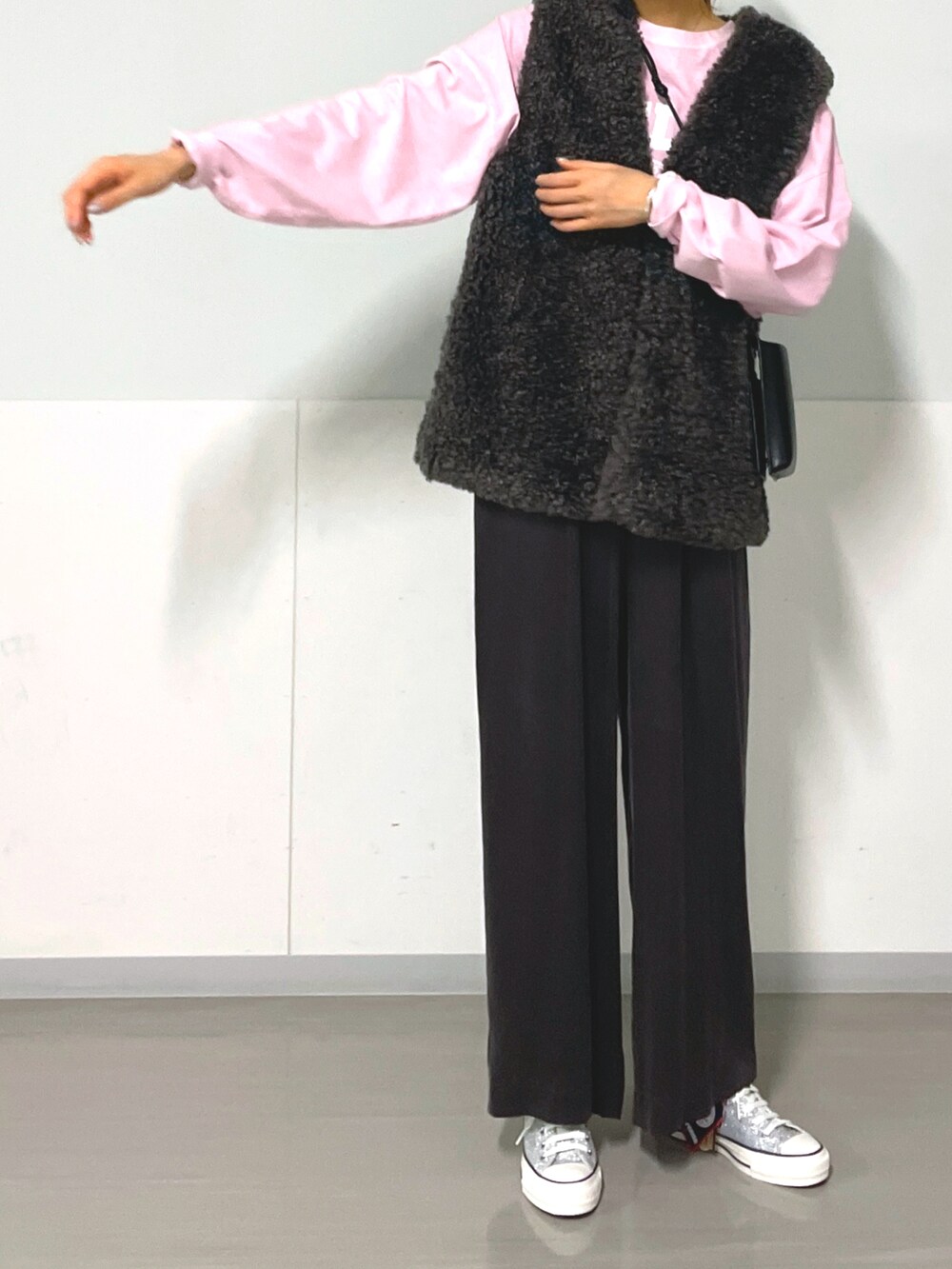 グレー系のベスト、グレー系のその他パンツ、シルバー系のスニーカーを着用したレディースの秋コーディネートの3枚目の写真