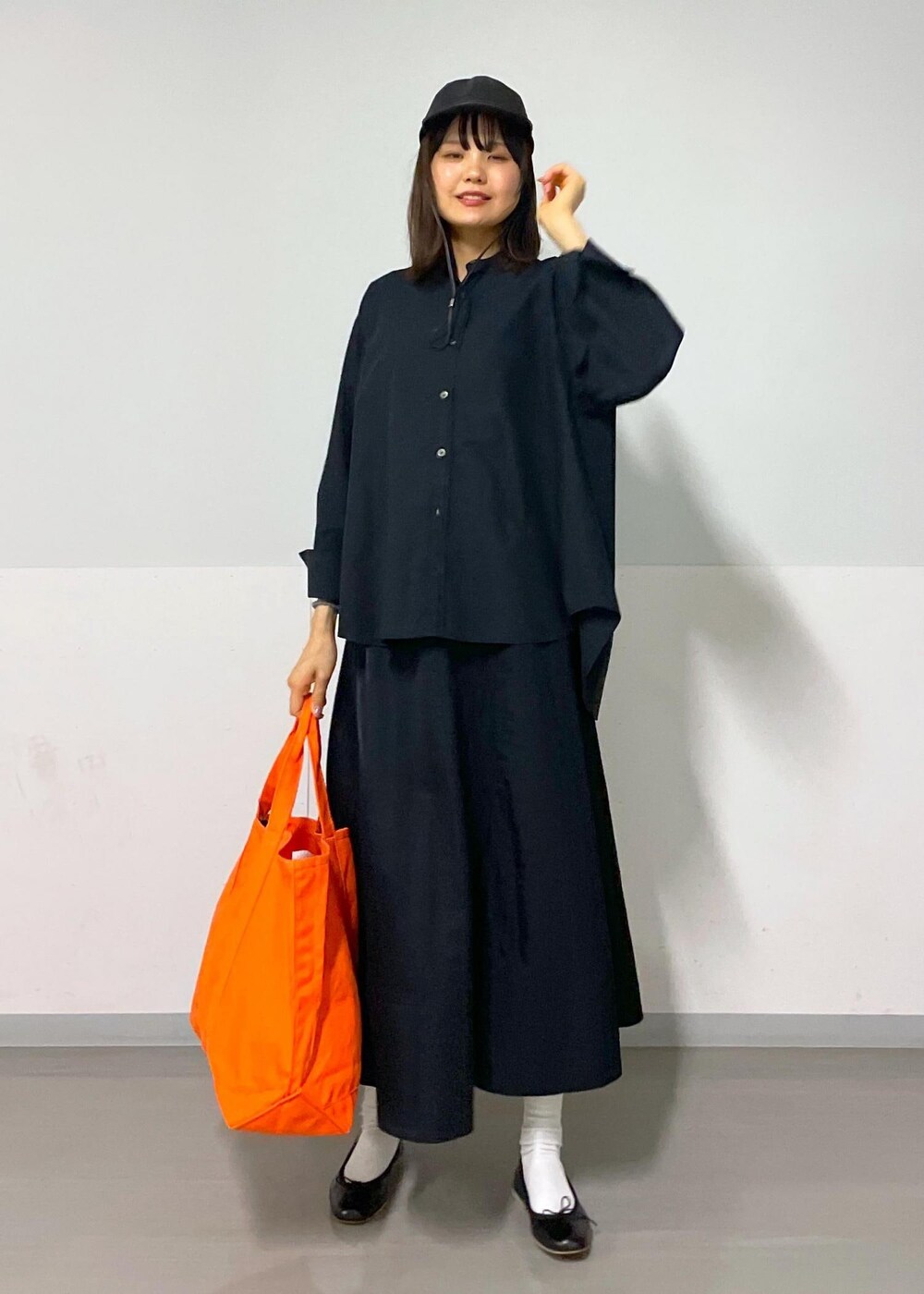 ブラック系のスカート、ブラック系のバレエシューズ、ホワイト系のカーディガン/ボレロを着用したレディースの秋コーディネートの4枚目の写真