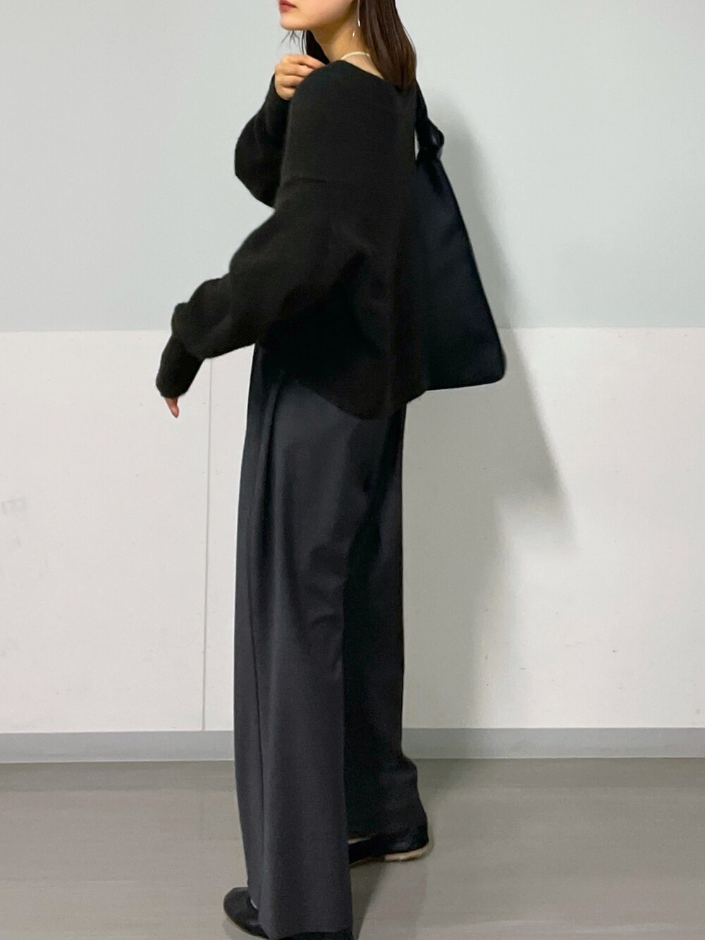 ブラウン系のニット/セーター、グレー系のスラックス、ブラック系のパンプスを着用したレディースの秋コーディネートの5枚目の写真