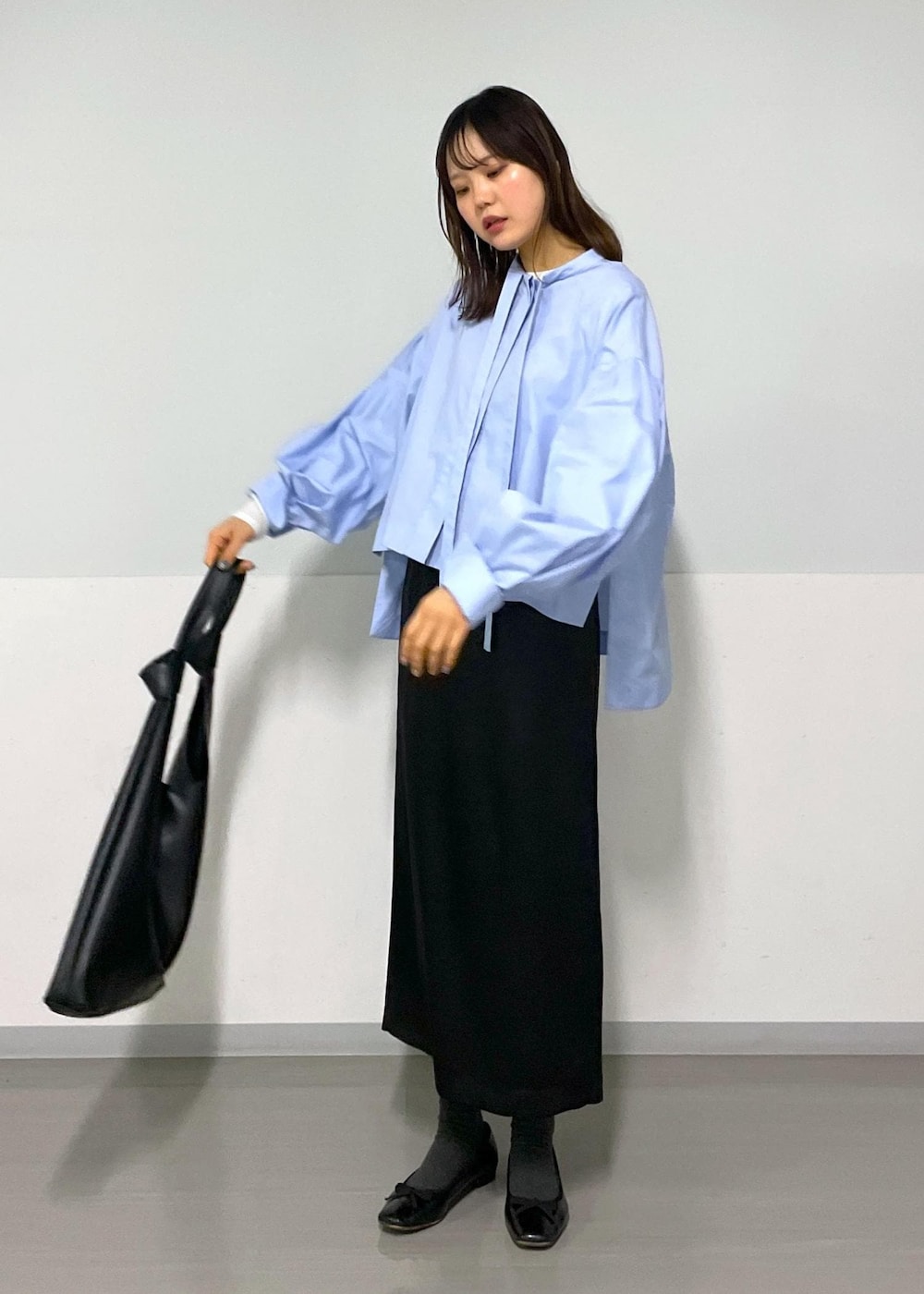 ブルー系のシャツ/ブラウス、ブラック系のトートバッグ、ブラック系のスカートを着用したレディースの冬コーディネートの3枚目の写真