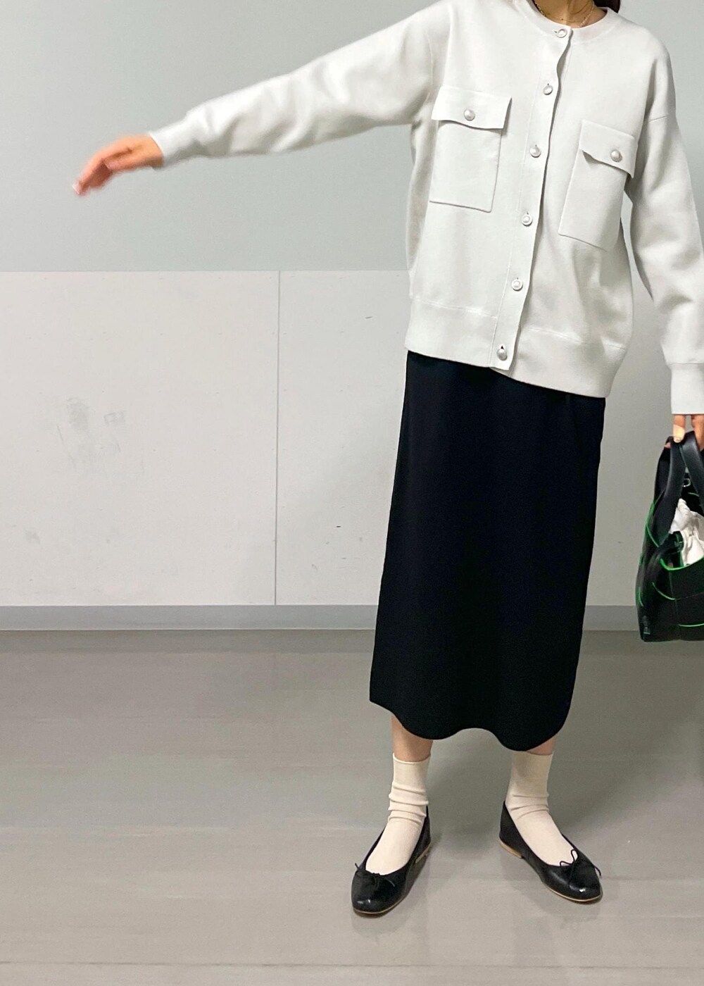 ブラック系のバレエシューズ、ブラック系のトートバッグ、グレー系のカーディガン/ボレロを着用したレディースの秋コーディネートの3枚目の写真