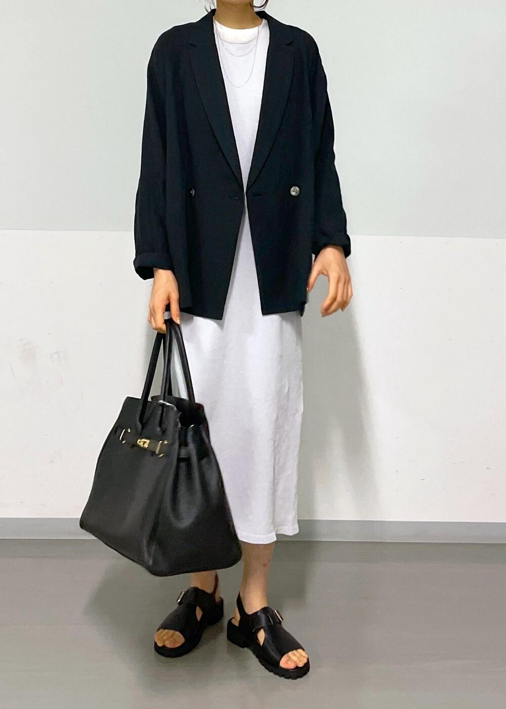 ブラック系のサンダル、グレー系のワンピース、ホワイト系のTシャツ/カットソーを着用したレディースの冬コーディネートの4枚目の写真