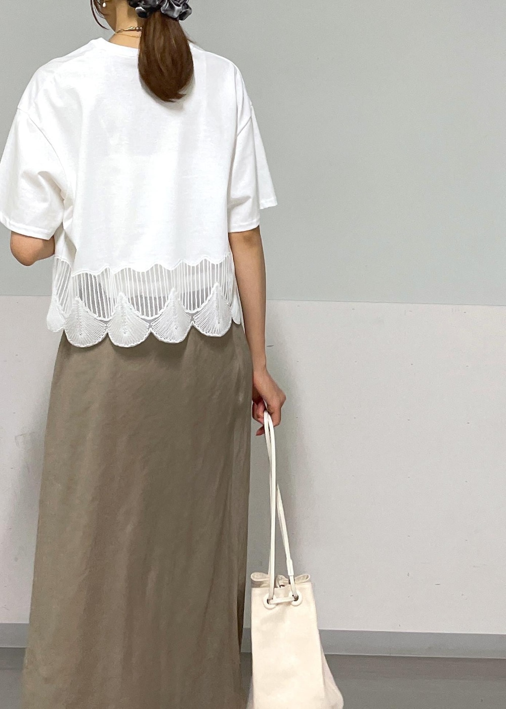 ホワイト系のキャミソール、シルバー系のサンダル、グリーン系のスカートを着用したレディースの夏コーディネートの9枚目の写真