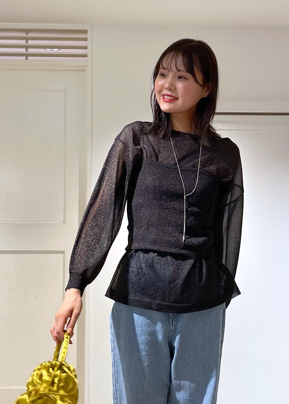 イエロー系のショルダーバッグ、ブルー系のデニムパンツ、ブラック系のTシャツ/カットソーを着用したレディースの夏コーディネートの5枚目の写真