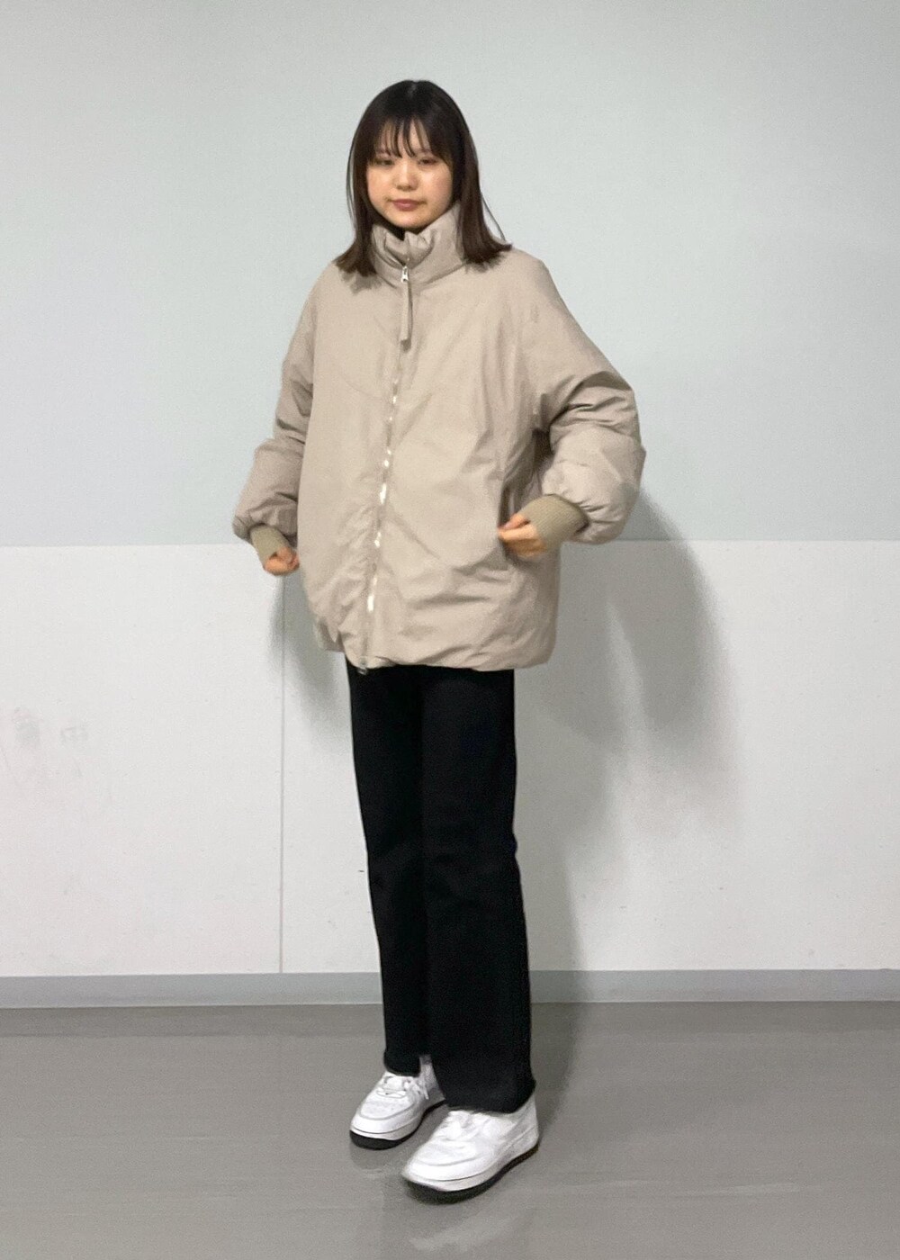 グレー系のスウェット、ベージュ系のダウンジャケット/コート、グレー系のデニムパンツを着用したレディースの冬コーディネートの5枚目の写真