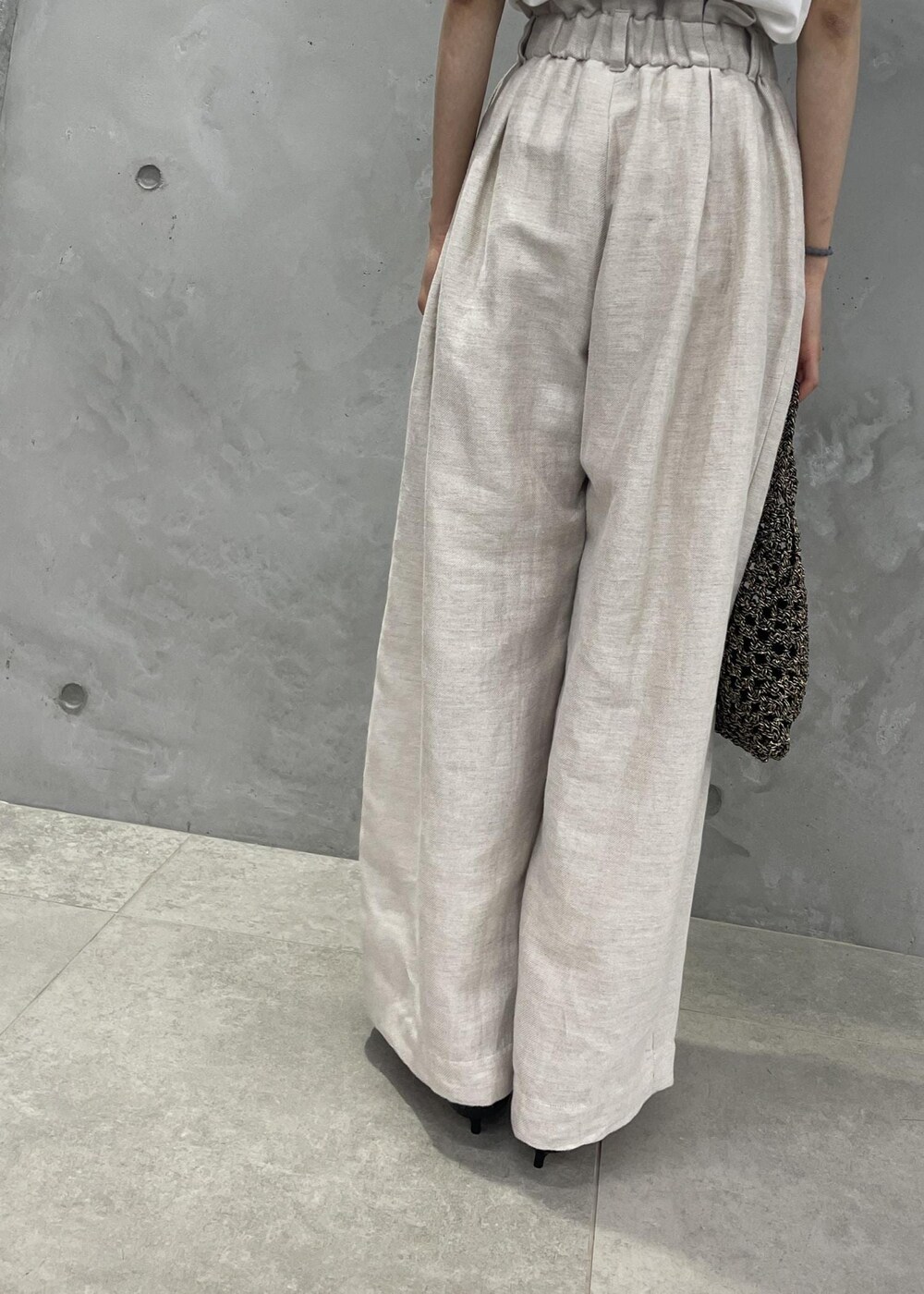 ブラック系のサンダル、ホワイト系のスラックス、ホワイト系のテーラードジャケットを着用したレディースの春コーディネートの5枚目の写真