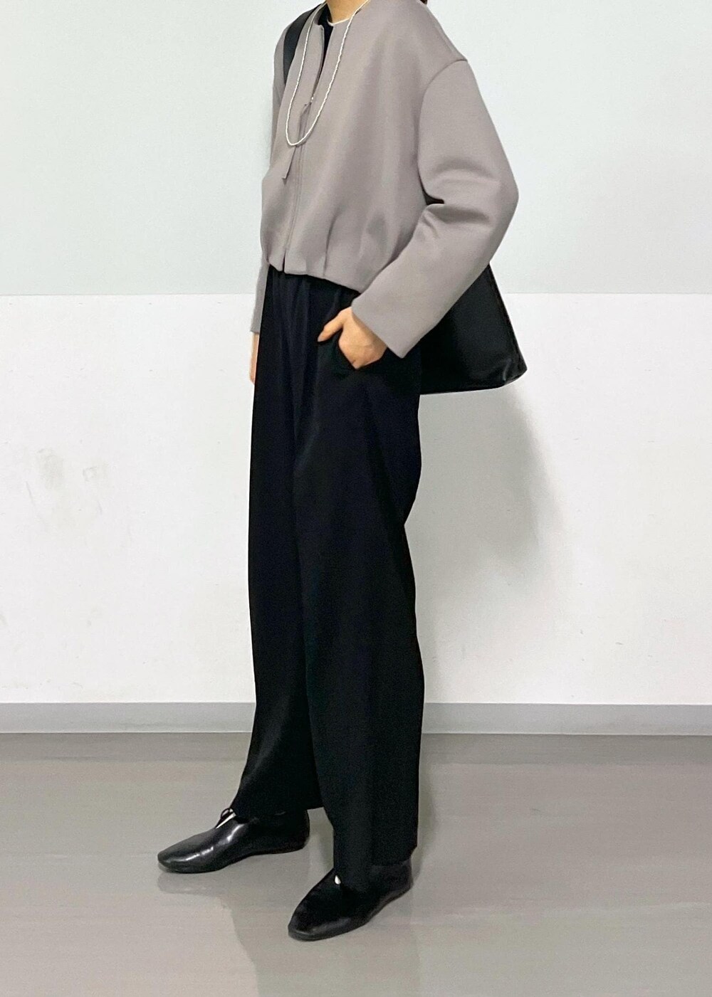 ブラック系のカーディガン/ボレロ、グレー系のTシャツ/カットソー、ブラック系のショルダーバッグを着用したレディースの春コーディネートの4枚目の写真