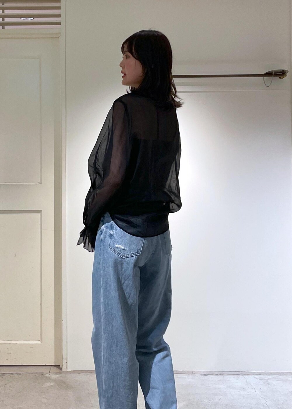 グレー系のノーカラージャケット、ブルー系のデニムパンツ、ブラック系のボストンバッグを着用したレディースの夏コーディネートの8枚目の写真