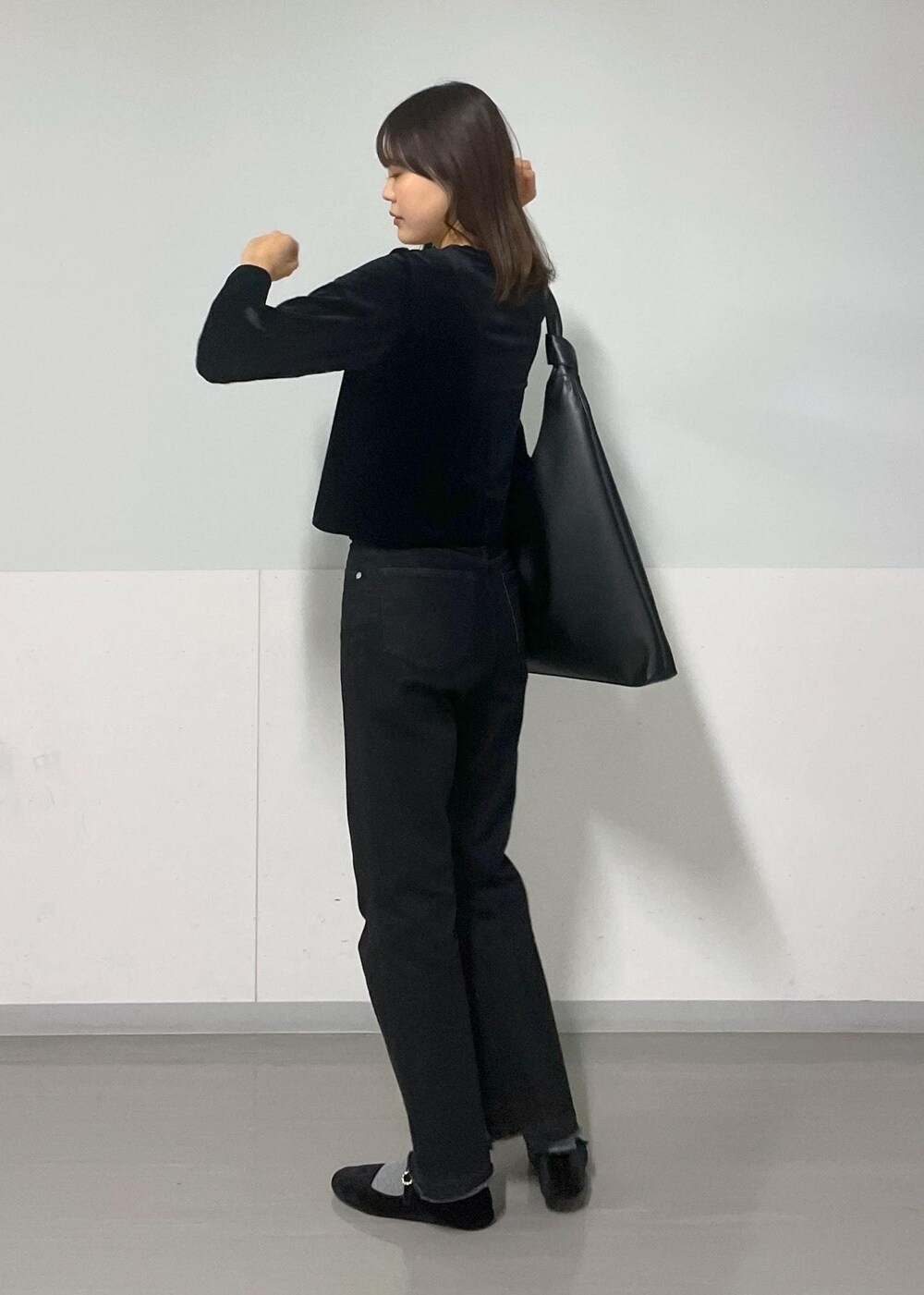 グレー系のTシャツ/カットソー、ブラック系のトートバッグ、グレー系のデニムパンツを着用したレディースの冬コーディネートの2枚目の写真