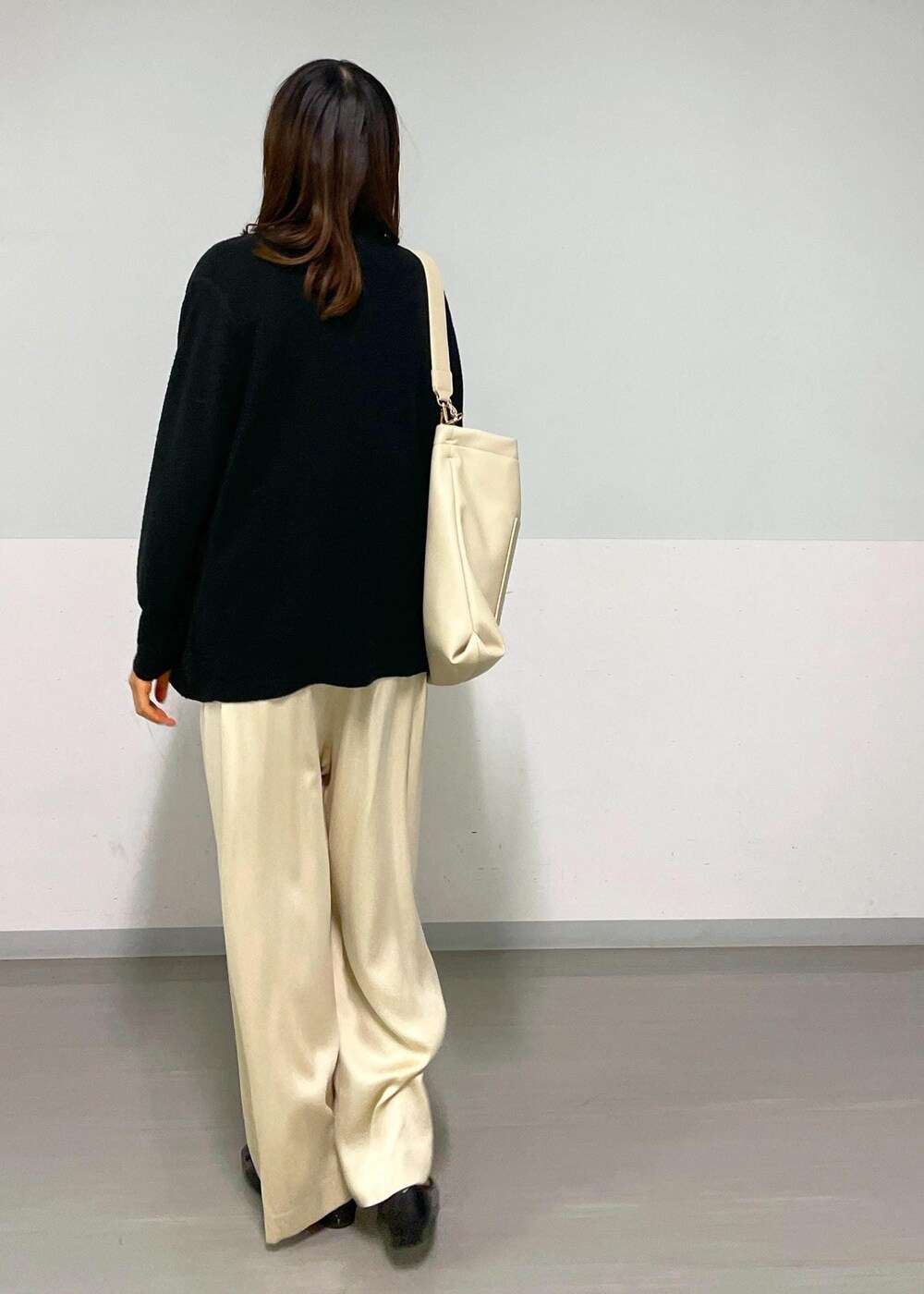 ベージュ系のその他パンツ、ブラック系のカーディガン/ボレロ、ベージュ系のトートバッグを着用したレディースの冬コーディネートの6枚目の写真