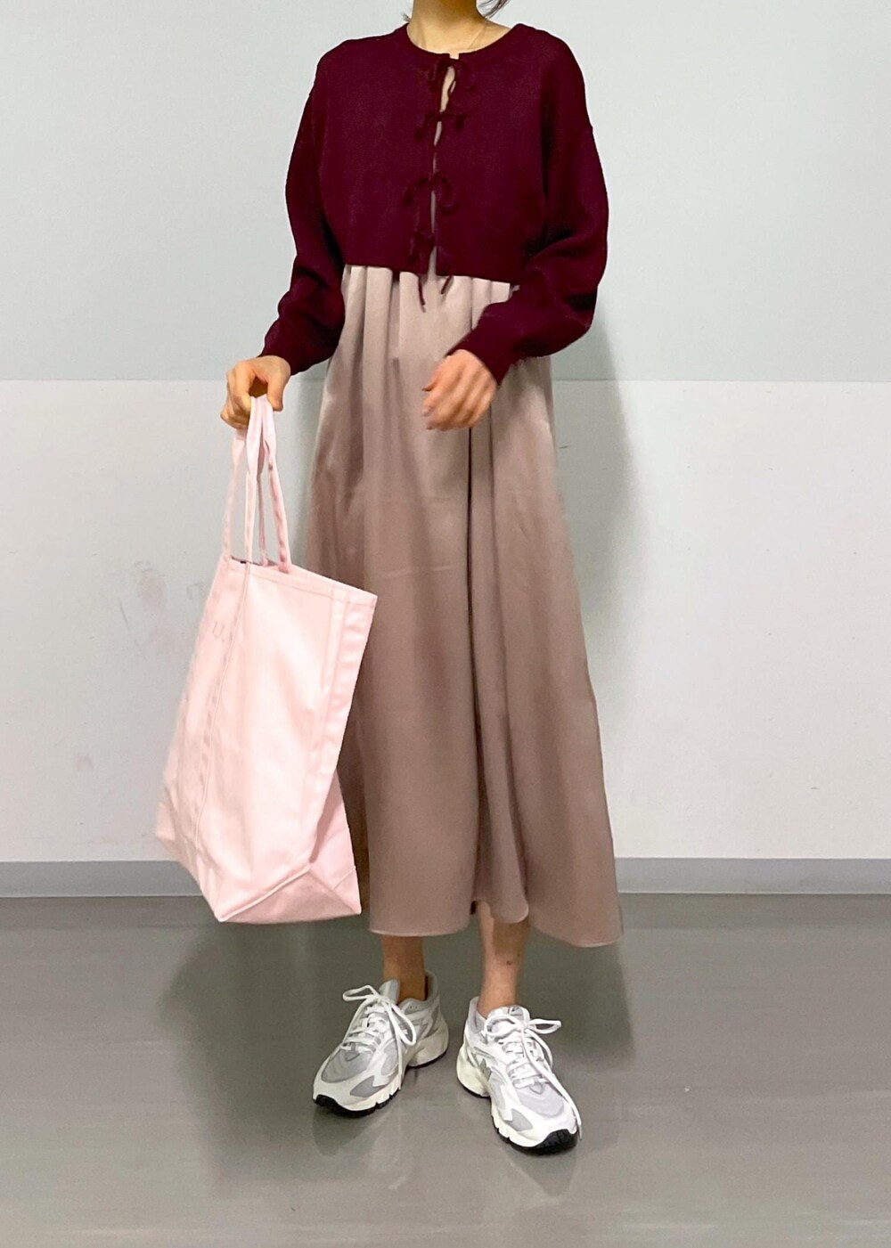 レッド系のニット/セーター、イエロー系のワンピース、ホワイト系のスニーカーを着用したレディースの春コーディネートの8枚目の写真