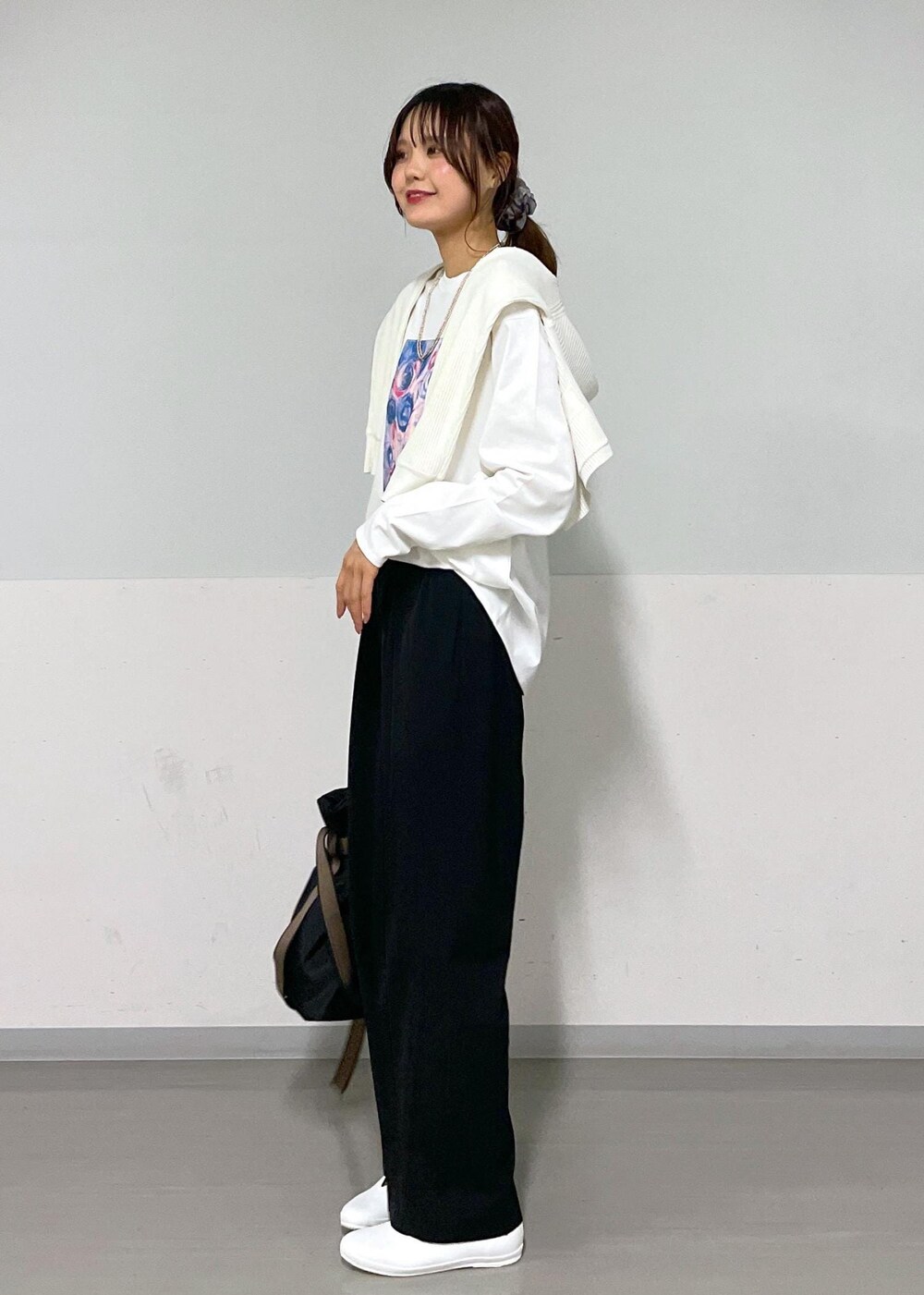 ホワイト系のカーディガン/ボレロ、ブラック系のスラックス、ブラック系のトートバッグを着用したレディースの夏コーディネートの2枚目の写真