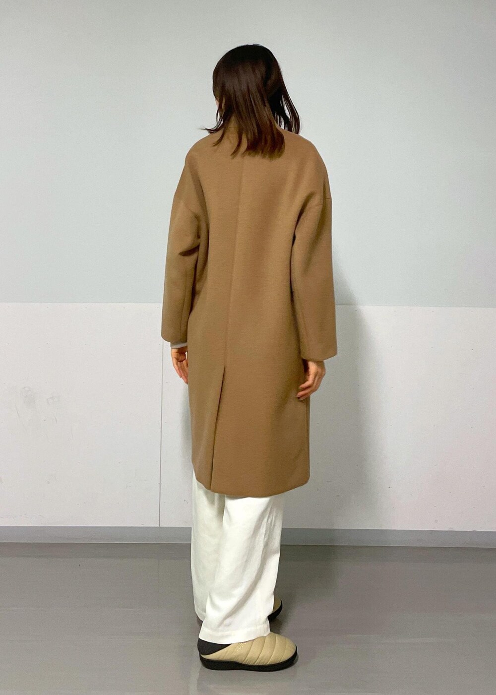 ブラック系のショルダーバッグ、イエロー系のチェスターコート、ベージュ系のカーディガン/ボレロを着用したレディースの冬コーディネートの8枚目の写真