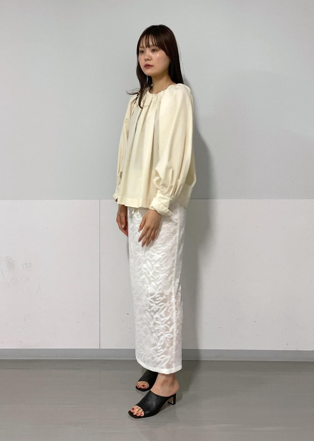 ブラック系のショルダーバッグ、ブラック系のサンダル、グリーン系のタンクトップを着用したレディースの夏コーディネートの4枚目の写真