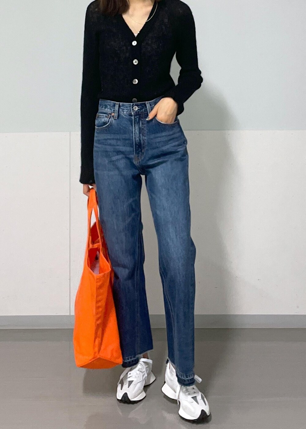 グレー系のタンクトップ、ブラック系のカーディガン/ボレロ、ブルー系のデニムパンツを着用したレディースの秋コーディネートの10枚目の写真
