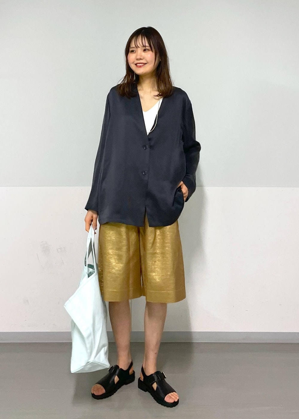 ゴールド系のその他パンツ、グレー系のノーカラージャケット、ブラック系のサンダルを着用したレディースの春コーディネートの7枚目の写真