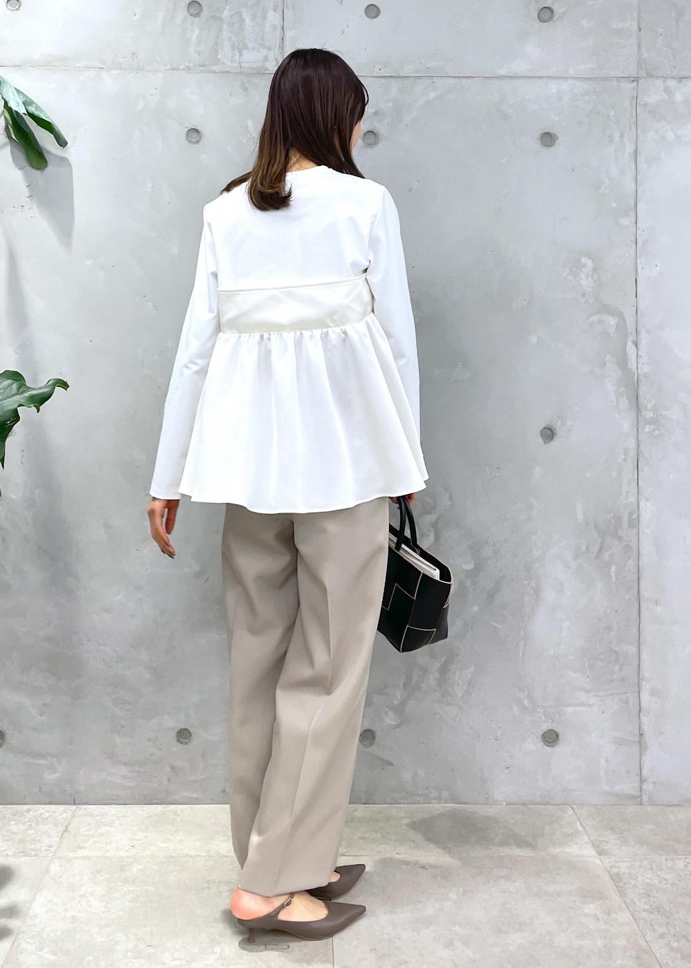 ベージュ系のその他パンツ、ブラック系のトートバッグ、ホワイト系のTシャツ/カットソーを着用したレディースの冬コーディネートの10枚目の写真