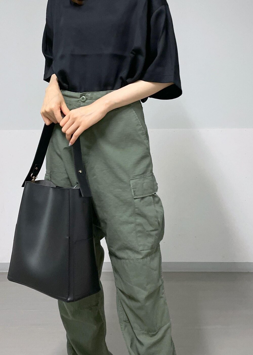 ホワイト系のトートバッグ、ブラック系のサンダル、グリーン系のカーゴパンツを着用したレディースの夏コーディネートの4枚目の写真