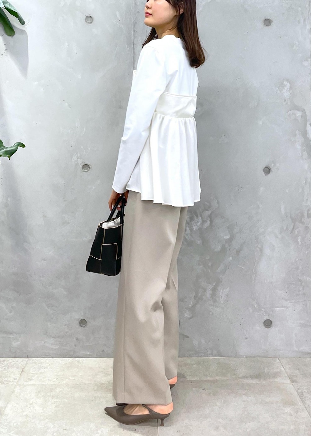 ベージュ系のその他パンツ、ブラック系のトートバッグ、ホワイト系のTシャツ/カットソーを着用したレディースの冬コーディネートの4枚目の写真