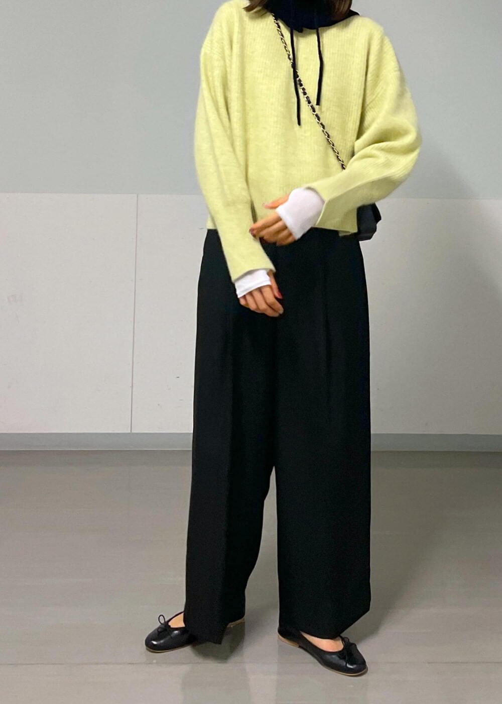 ブラック系のショルダーバッグ、イエロー系のニット/セーター、ホワイト系のTシャツ/カットソーを着用したレディースの秋コーディネートの4枚目の写真