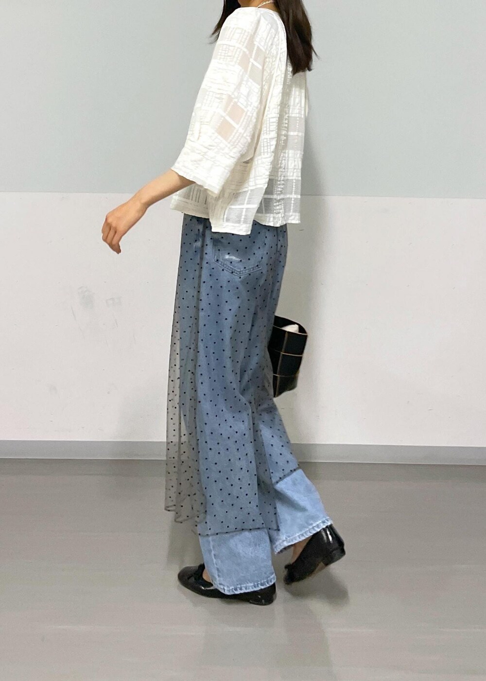 ブラック系のトートバッグ、ホワイト系のタンクトップ、グレー系のスカートを着用したレディースの夏コーディネートの8枚目の写真