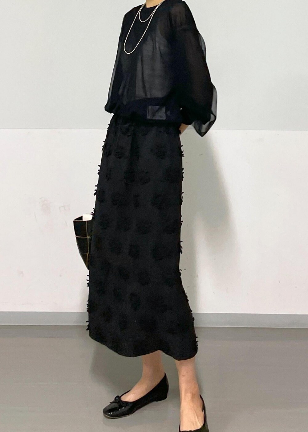 ブラック系のトートバッグ、ホワイト系のキャミソール、ブラック系のTシャツ/カットソーを着用したレディースの春コーディネートの6枚目の写真