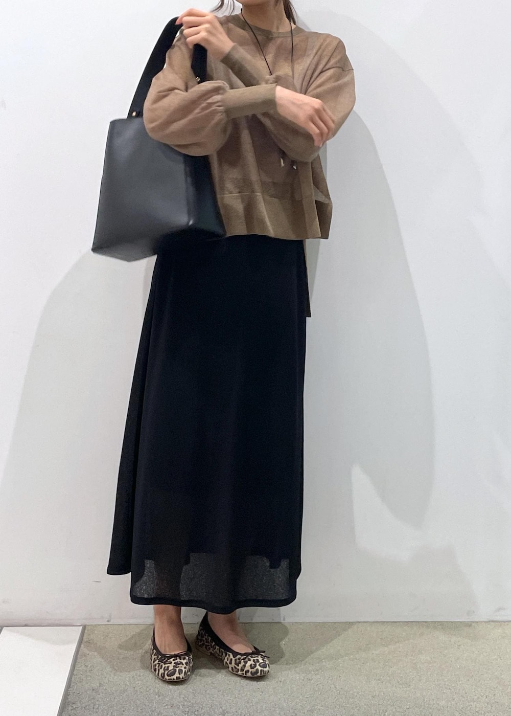 ブラック系のスカート、ゴールド系のTシャツ/カットソー、ブラック系のトートバッグを着用したレディースの夏コーディネートの4枚目の写真