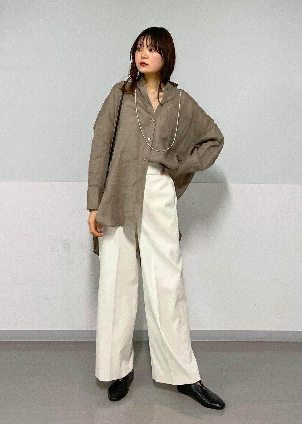 ブラック系のショルダーバッグ、グリーン系のシャツ/ブラウス、ホワイト系のその他パンツを着用したレディースの春コーディネートの6枚目の写真