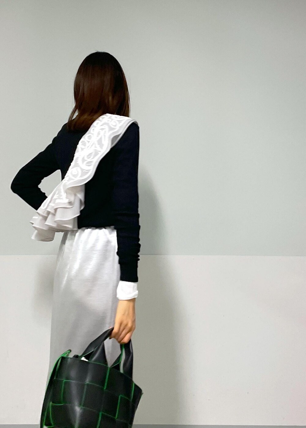 ブラック系のトートバッグ、ホワイト系のその他シューズ、ブラック系のTシャツ/カットソーを着用したレディースの冬コーディネートの7枚目の写真