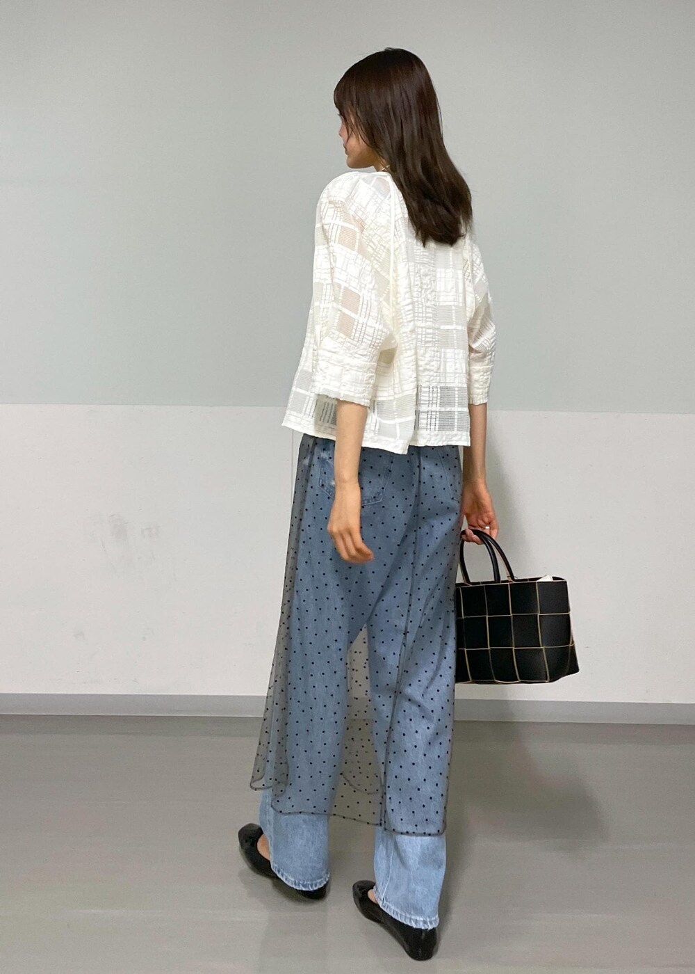 ブラック系のトートバッグ、ホワイト系のタンクトップ、グレー系のスカートを着用したレディースの夏コーディネートの9枚目の写真