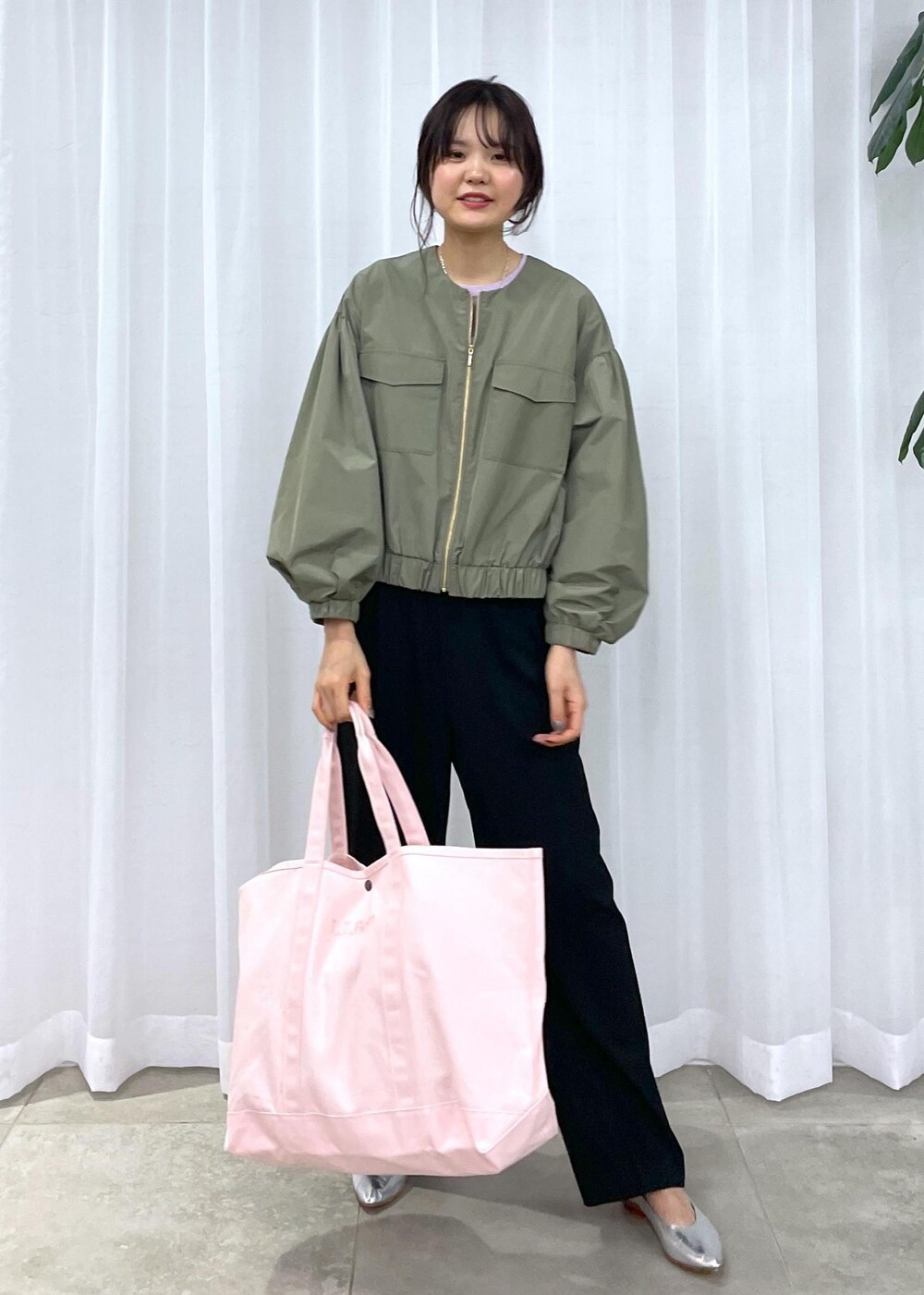 ブラック系のスラックス、グリーン系のブルゾン、シルバー系のパンプスを着用したレディースの冬コーディネートの4枚目の写真