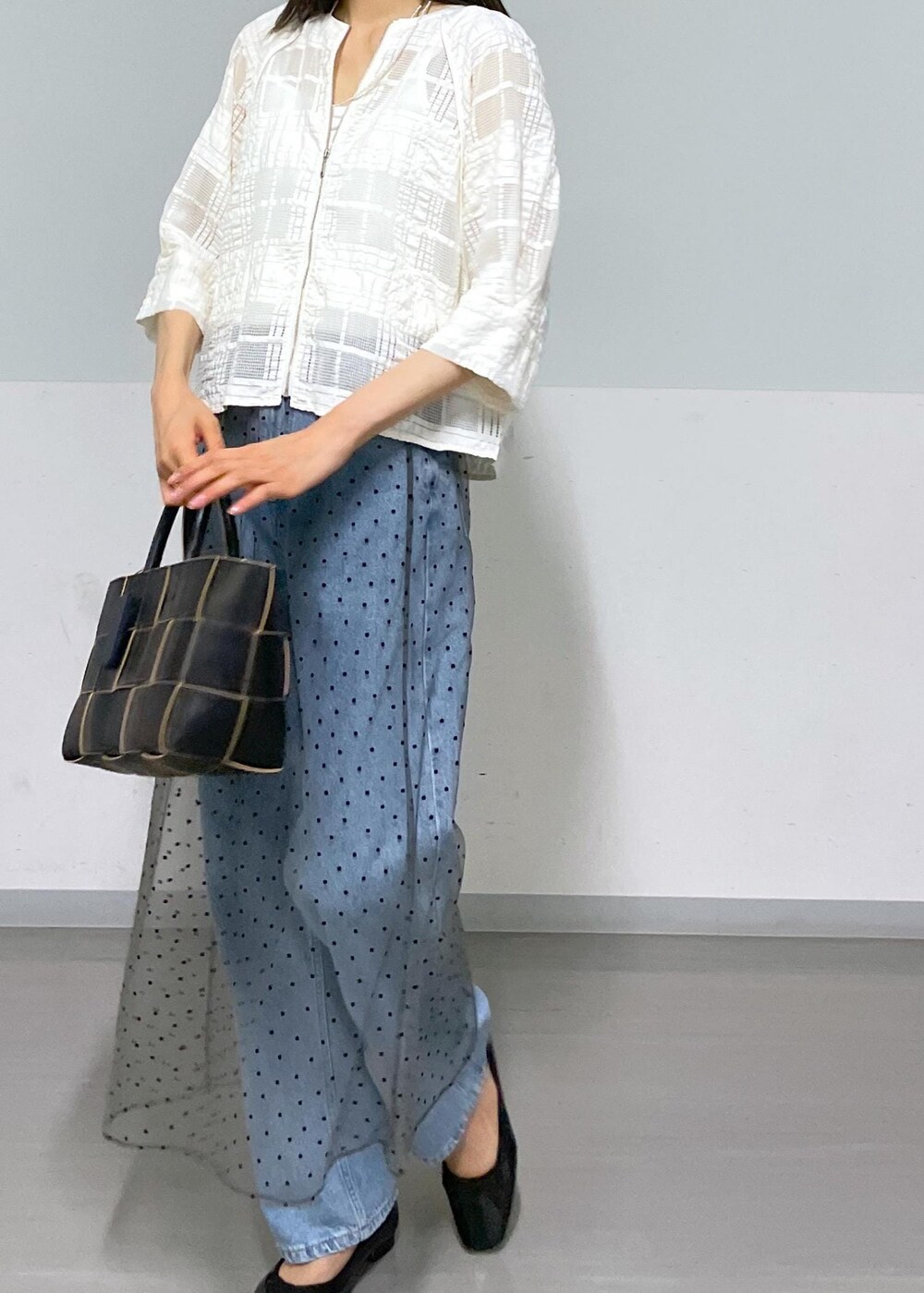 ブラック系のトートバッグ、ホワイト系のタンクトップ、グレー系のスカートを着用したレディースの夏コーディネートの5枚目の写真