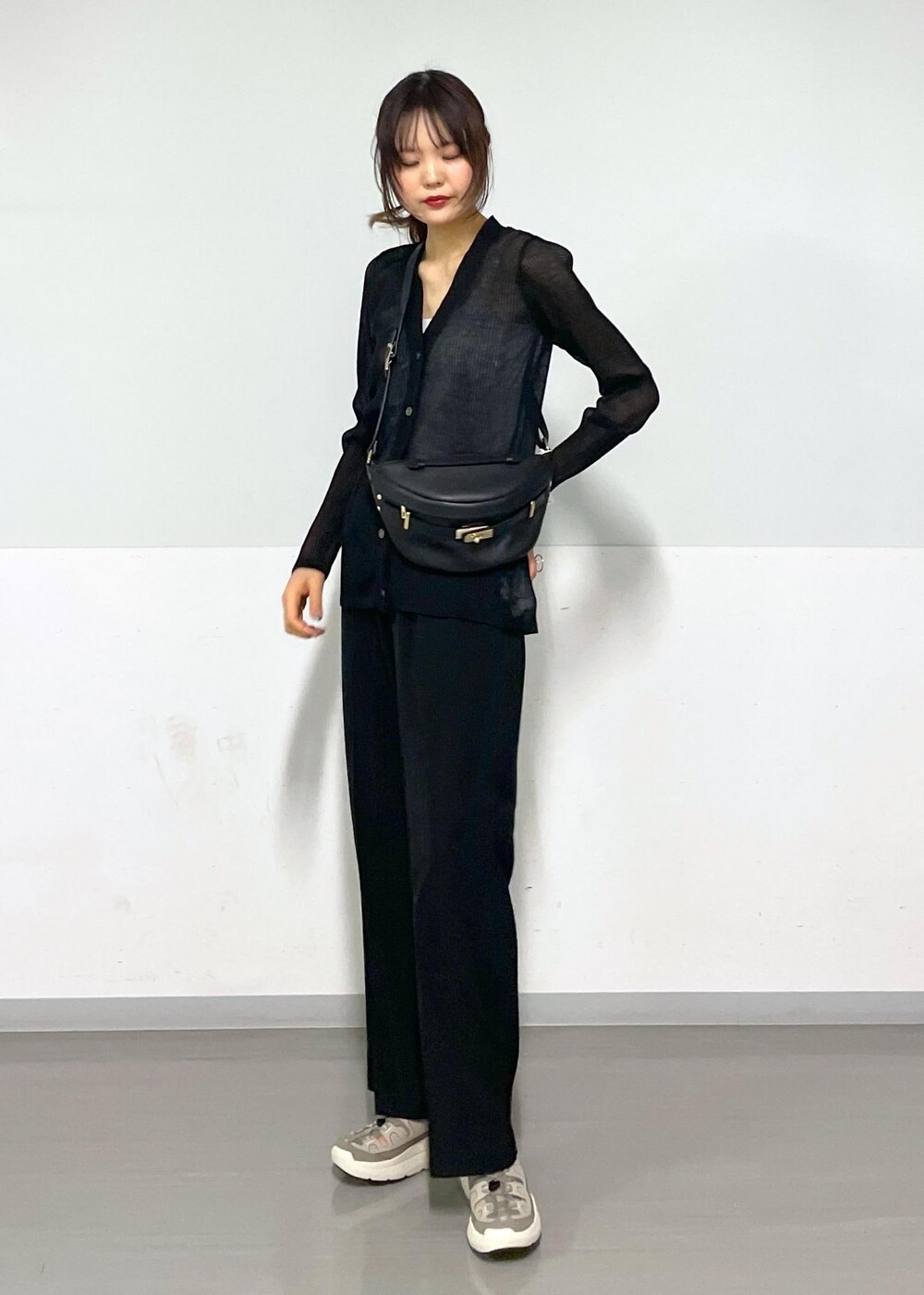 グレー系のタンクトップ、ブラック系のボディバッグ/ウエストポーチ、ブラック系のカーディガン/ボレロを着用したレディースの春コーディネートの3枚目の写真