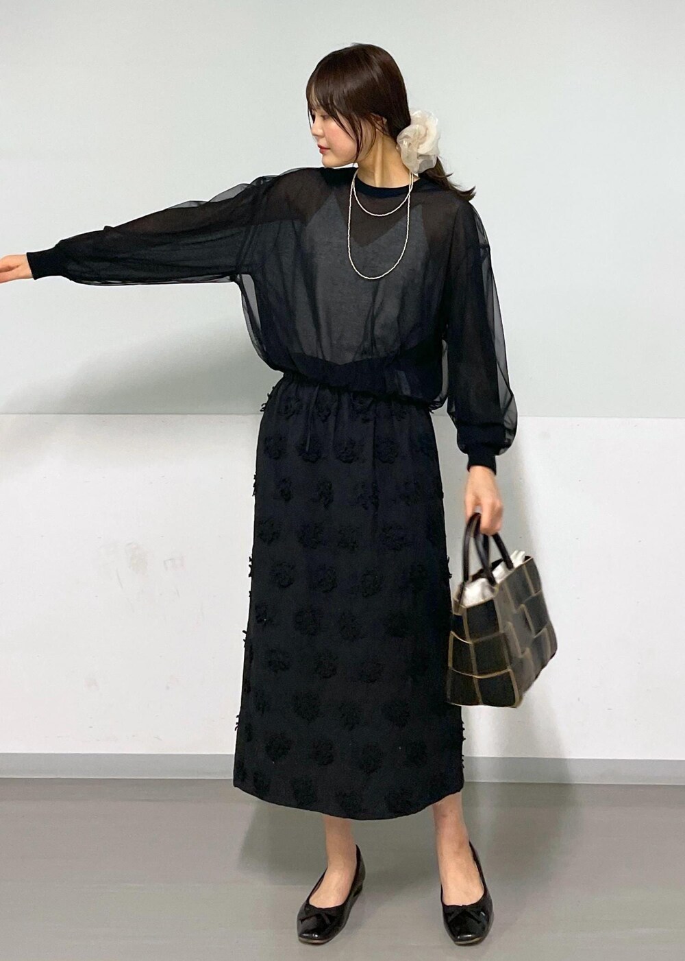 ブラック系のトートバッグ、ホワイト系のキャミソール、ブラック系のTシャツ/カットソーを着用したレディースの春コーディネートの4枚目の写真