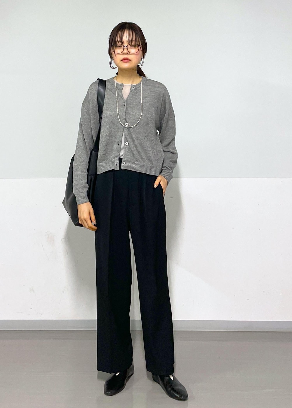 グレー系のカーディガン/ボレロ、グレー系のTシャツ/カットソー、ブラック系のスラックスを着用したレディースの春コーディネートの7枚目の写真