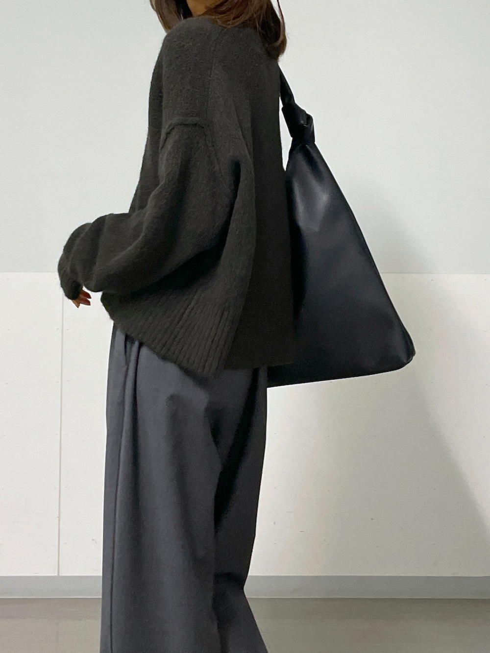 ブラウン系のニット/セーター、グレー系のスラックス、ブラック系のパンプスを着用したレディースの秋コーディネートの4枚目の写真