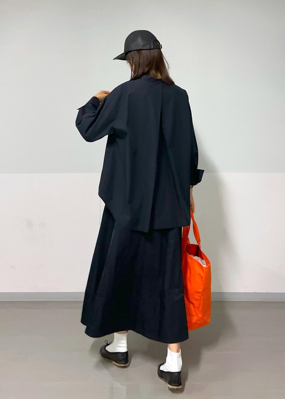 ブラック系のスカート、ブラック系のバレエシューズ、ホワイト系のカーディガン/ボレロを着用したレディースの秋コーディネートの3枚目の写真