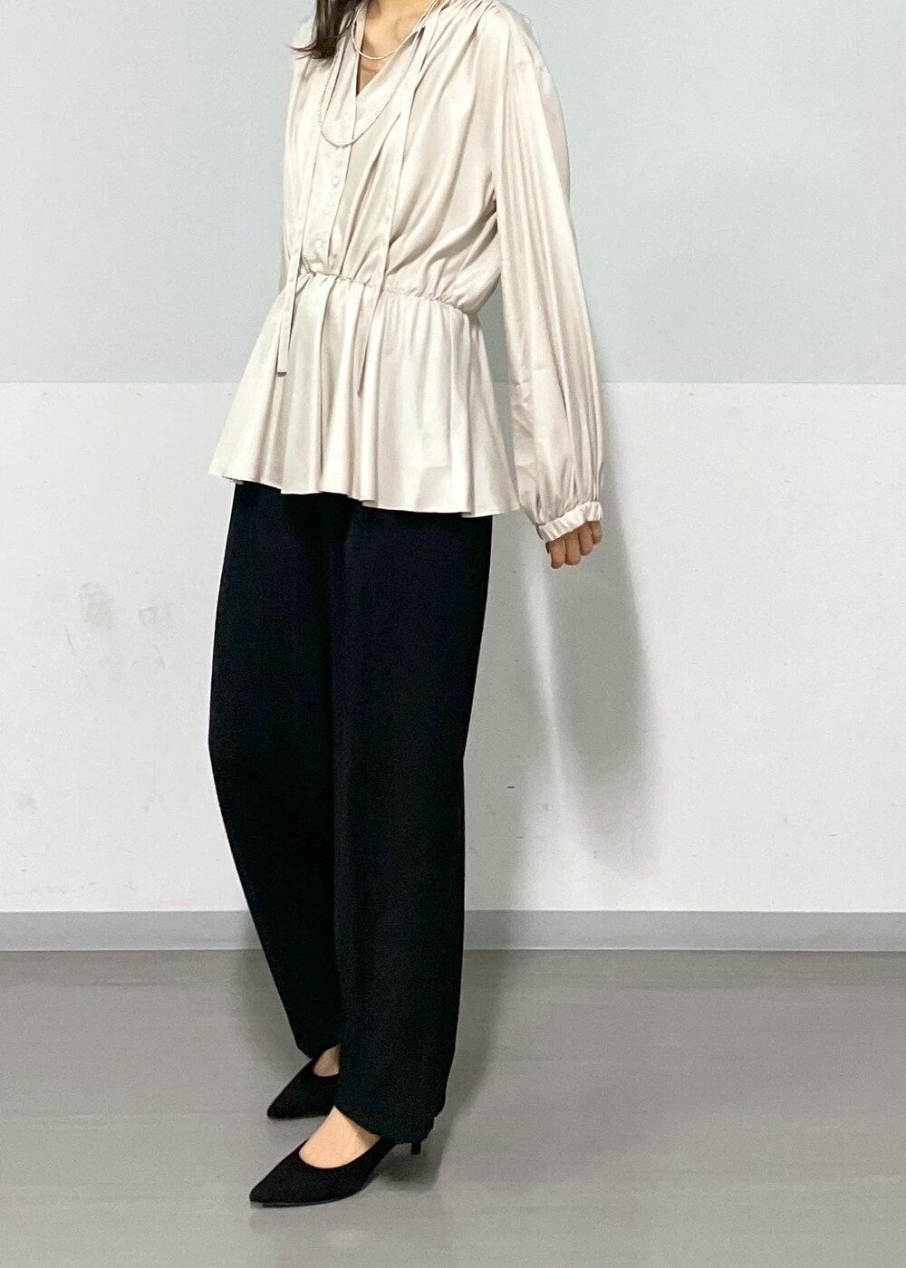 ブラック系のトートバッグ、ブラック系のスラックス、ベージュ系のシャツ/ブラウスを着用したレディースの春コーディネートの4枚目の写真