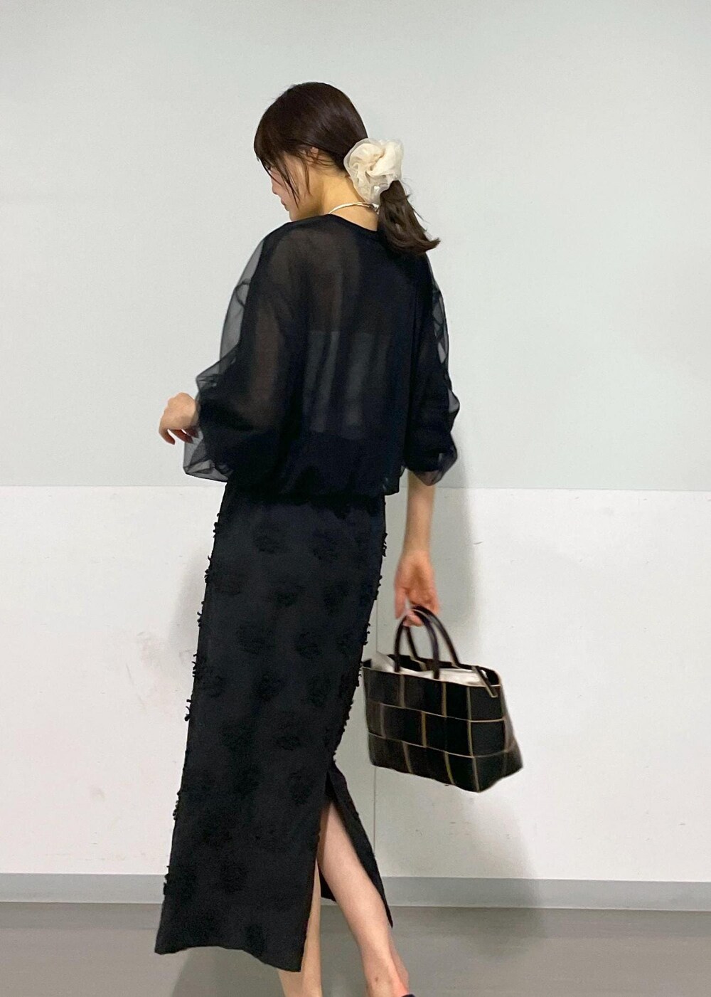 ブラック系のトートバッグ、ホワイト系のキャミソール、ブラック系のTシャツ/カットソーを着用したレディースの春コーディネートの3枚目の写真