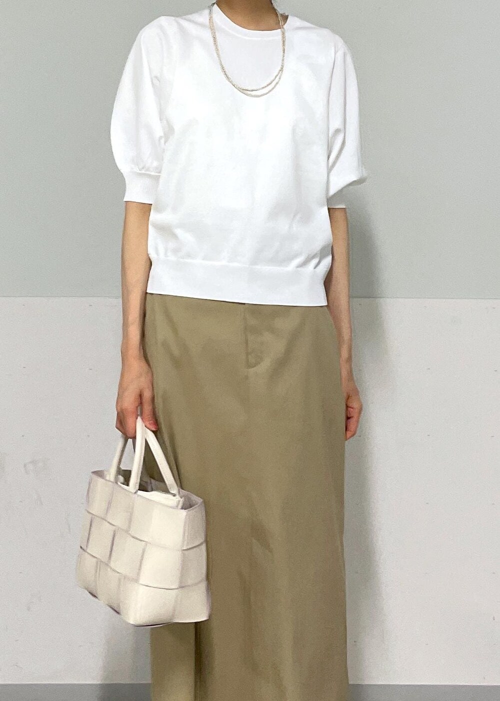 ホワイト系のトートバッグ、ベージュ系のスカート、ベージュ系のカーディガン/ボレロを着用したレディースの夏コーディネートの5枚目の写真