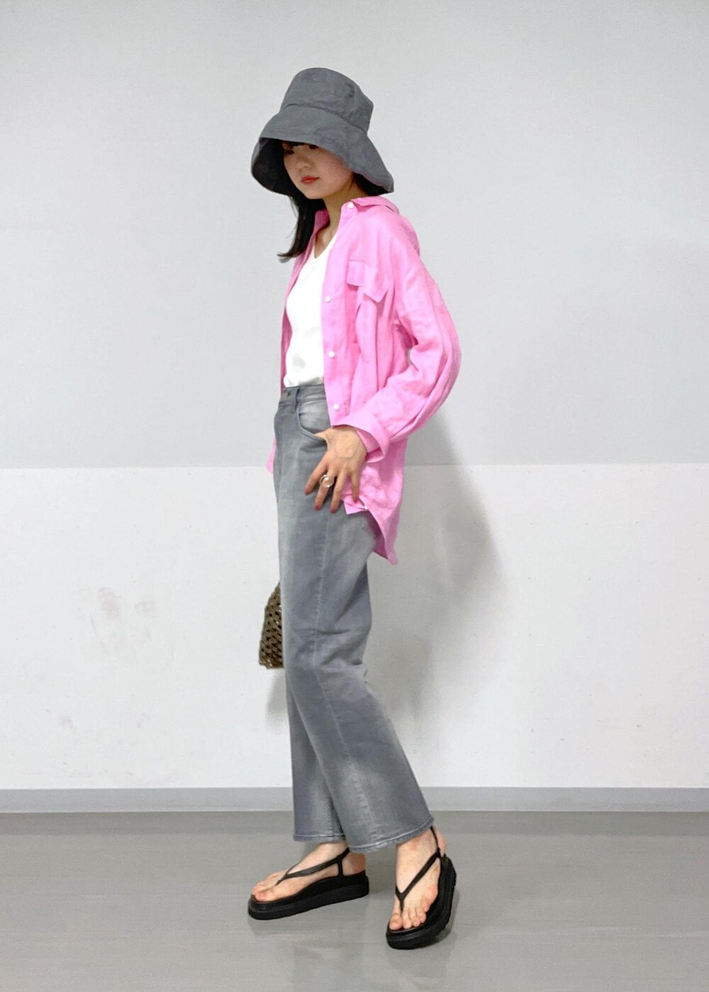 ブラック系のデニムパンツ、ブラック系のサンダル、ブラック系のハンドバッグを着用したレディースの春コーディネートの3枚目の写真